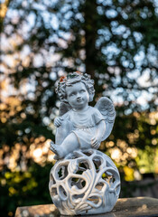 Fototapeta premium schöner Engel mit Blumen im Haar auf einer Kugel