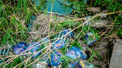 a collection of plastic waste disposed of by the river by residents