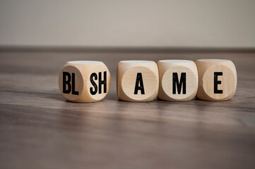 Cubes, blocks or dice with blame and shame on wooden background - obrazy, fototapety, plakaty