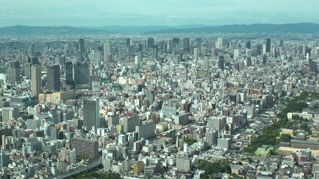 OSAKA, JAPAN : Aerial high angle view of CITYSCAPE of OSAKA in day time. View of buildings and streets around Namba, Shinsaibashi, Umeda and Osaka train station. Wide view time lapse tracking shot.