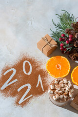 Obraz na płótnie Canvas Cup of hot cocoa with marshmallows and numbers 2021 from cocoa powder. The concept of cosy holidays and New Year.