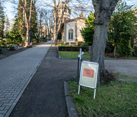 Hinweisschild über die Schließungszeit auf dem Friedhof