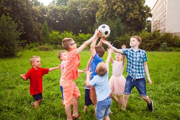 The kids play with a ball in the school garden