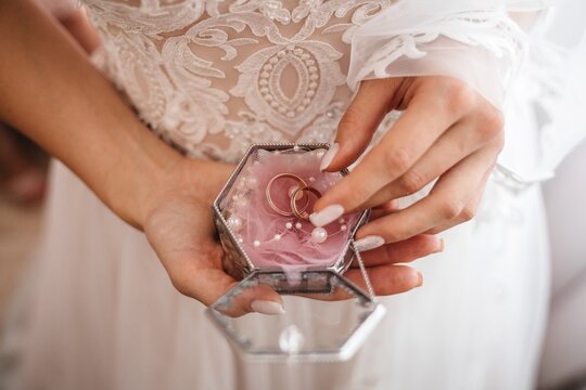 Midsection Of Bride Holding Rings In Jewelry Box During Wedding Ceremony