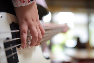 Young girl playing a white electric guitar