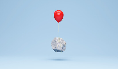 Red balloon with a heavy stone on blue studio background