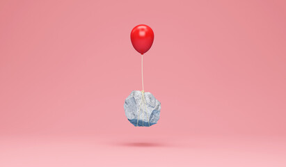 Red balloon with a heavy stone on pink studio background