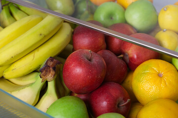 Box full of fresh fruit inside of a fridge