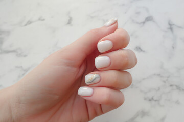 White manicure with shiny streaks, fashionable decoration of women's nails