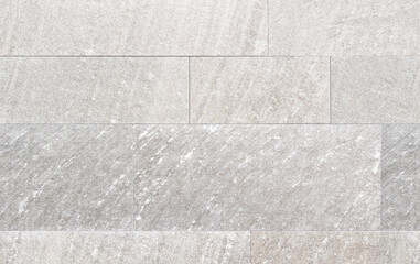 Detail der Wandverkleidung einer Fassade aus grauen Steinfliesen in verschiedenen Größen