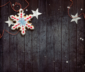 Christmas decoration on wooden background. Snowflake shaped gingerbread cookie.