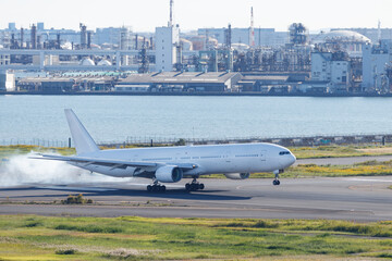 羽田空港でタイヤから白い煙を上げて着陸する飛行機