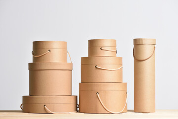 Set of kraft cardboard gift boxes of a round shape on a gray background