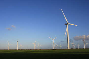 Fototapeta premium Wind farm turbines that produce electricity energy. Windmill Wind power technology productions Wind turbines standing in green field - stock footage