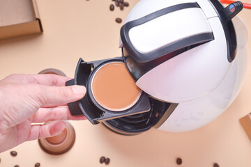 Woman hand puts capsule to coffee machine