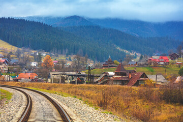 View of the city in the mountain valley and the railway in autumn
