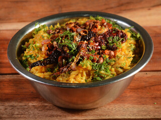 Dal khichdi or Khichadi, Tasty Indian recipe served in bowl over rustic wooden background, The food made of dal and rice combined with whole spices, onions, garlic and tomatoes etc. Selective focus