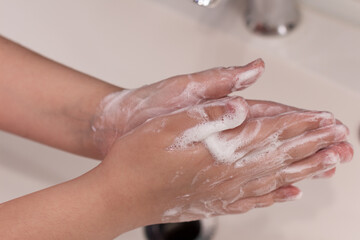 Washing hands with soap foam