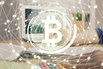 Cryptocurrency hologram, bitcoin, ico theme over hands taking notes background. Concept of...