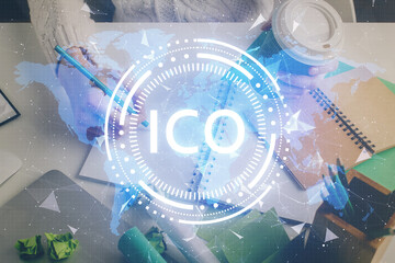 Cryptocurrency hologram, bitcoin, ico theme over hands taking notes background. Concept of...