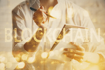 Cryptocurrency hologram, bitcoin, ico theme over hands taking notes background. Concept of blockchain. Multi exposure