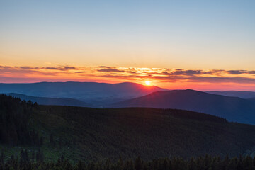 Sunset with colorful sky from Dlouhe strane hill in Jeseniky mountains in Czech republic