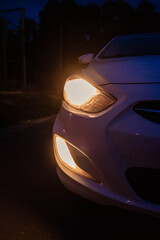 headlights of a white car at dusk