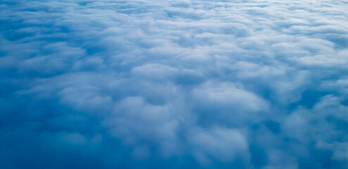 White clouds view at a height from a plane window
