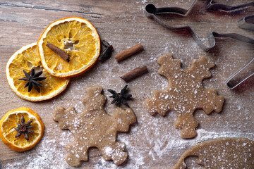 Two snowflakes  and dried orange slices and cinnamon sticks on a wooden background with flour