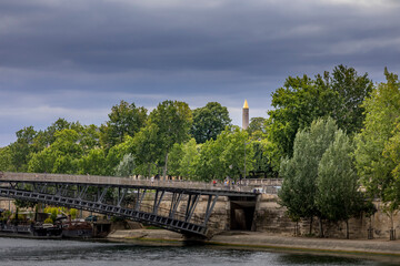 Naklejka na ściany i meble Paris, France - June 30, 2020: Top of the obelisk of Concorde square and Seine river embankment in foreground in Paris