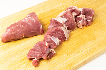 Chopped pieces of the most tender and soft pork meat on cutting board. Fresh and juicy pork tenderloin without fat for tasty bbq.