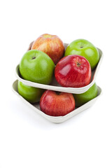Fresh red and green apples in pulp paper trays on top of each other. Studio photo isolated on white.
