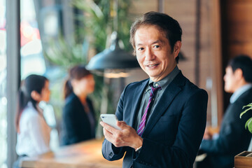 スマホを使う中高年のビジネスマン

