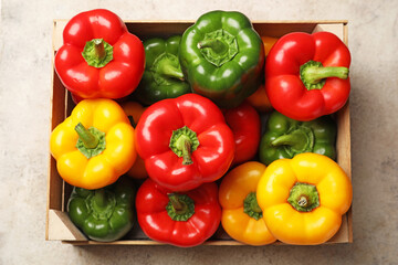 Fresh bell peppers in box on light background