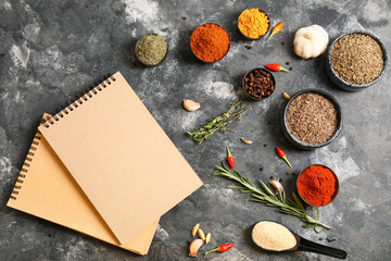 Notebooks for recipes and spices on grey background