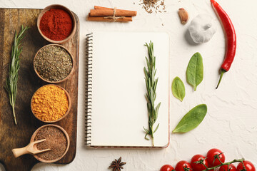 Notebook for recipes and spices on white table