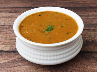 Authentic Indian popular food Dal fry or Traditional Indian soup lentils on rustic wooden background. selective focus