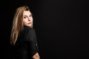 Fototapeta premium Studio portrait of a young beautiful girl with black background
