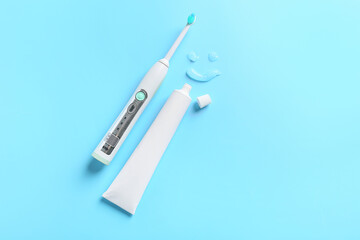 Obraz premium Electric tooth brush and paste on color background
