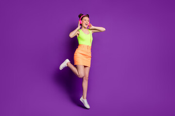 Full length body size view of attractive fit dreamy cheery girl jumping listening song singing having fun isolated on bright violet color background