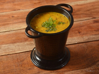 Authentic Indian popular food Dal fry or Traditional Indian soup lentils on rustic wooden background. selective focus