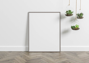 Verical metal frame mockup. Metal frame poster on wooden floor with white wall and plants. 3D illustrations.