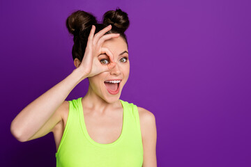 Close-up portrait of pretty funky cheerful girl showing ok-sign like monocle isolated over bright violet purple color background