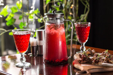 fresh fruit red punch lemonade jug and glass on wooden table at restaurant