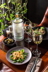 Baked salmon with cheese crust and fresh spinach on wooden table at restaurant