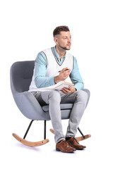 Male psychologist sitting in armchair on white background