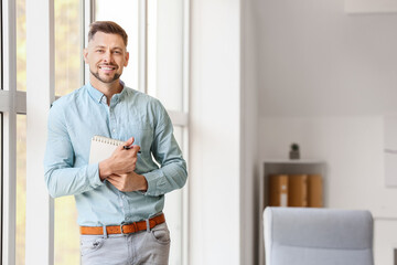 Portrait of male psychologist near window in office