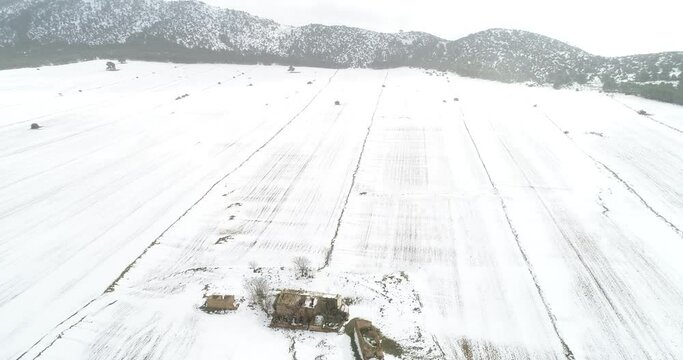Paisaje agrario nevado a vista de drone con casa abandonada