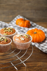 Cooling rack with tasty pumpkin muffins on table