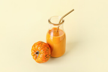 Bottle of tasty pumpkin smoothie on color background